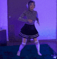 a woman in a striped shirt and a black skirt is dancing on a rug .