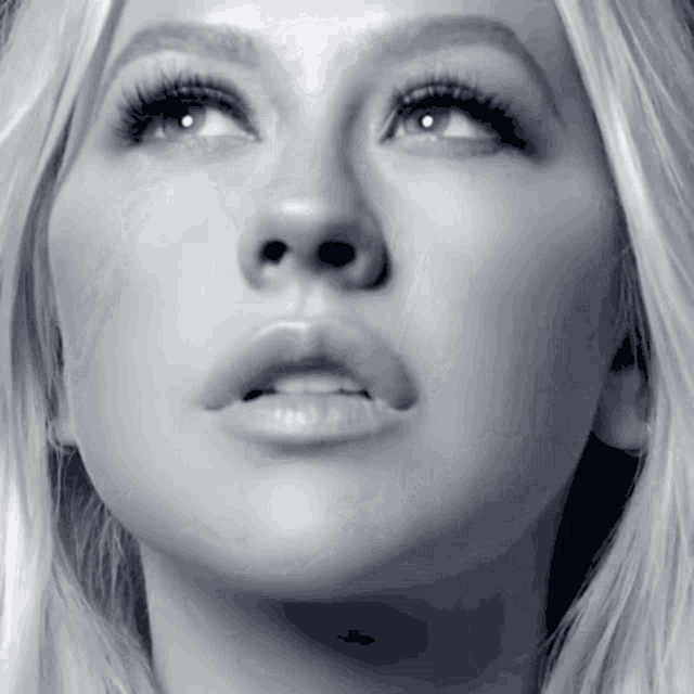 a woman 's face is shown in a black and white photo looking up