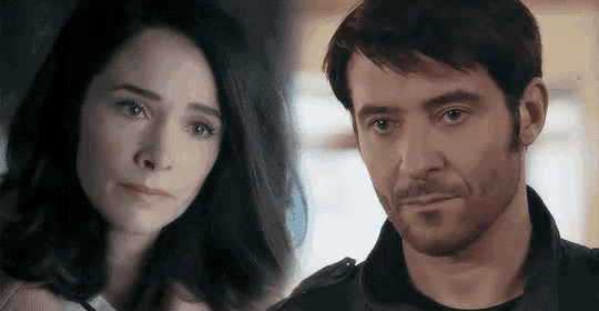 a man and a woman are looking at each other . the woman is crying and the man is smiling .