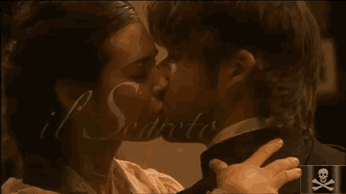 a man and a woman kissing in front of a sign that says il segreto