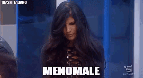 a woman with long hair says menomale in a foreign language