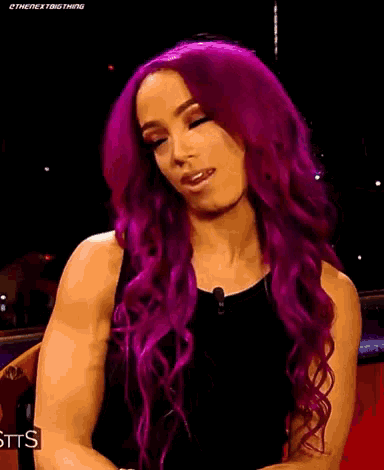 a woman with purple hair and a black shirt is smiling