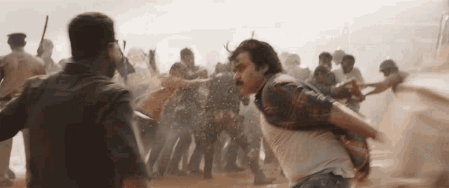a man in a plaid shirt is being attacked by a crowd of people .