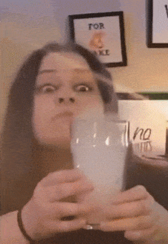 a woman holds a glass in front of a framed picture that says for sale