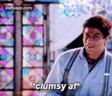 a man in a white coat is standing in front of a stained glass window and saying clumsy af .