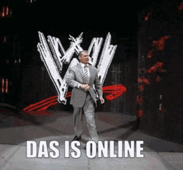 a man in a suit and tie is walking in front of a wwe logo and says das is online