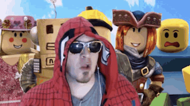 a man wearing a spiderman costume and sunglasses is standing in front of a group of lego characters .