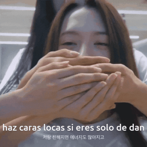 a woman is covering her mouth with her hands and the words haz caras locas si eres solo de dan are below her