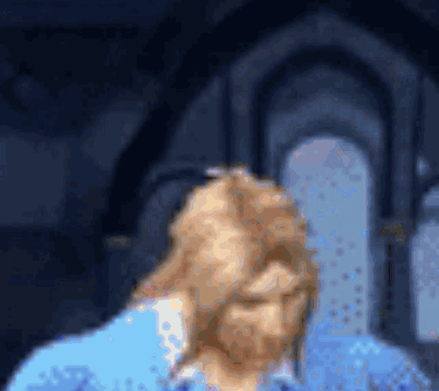 a blurry picture of a man in a blue shirt with a beard