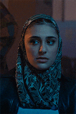 a woman wearing a scarf around her head and a leather jacket