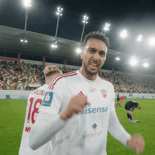 a soccer player wearing a white jersey with the word hisense on the front