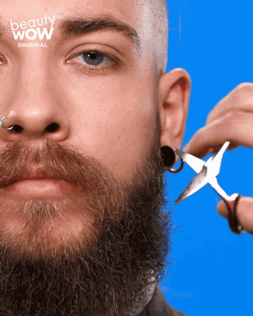 a man with a beard is getting his beard trimmed by a beauty wow stylist