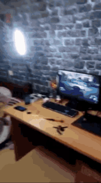 a computer monitor is on a desk with a brick wall in the background