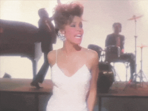 a woman in a white dress stands on a stage