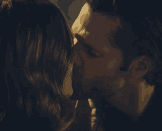 a close up of a man and woman kissing