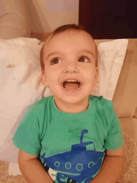 a young boy wearing a green shirt with a blue submarine on it