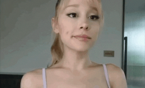 a woman in a bra is making a funny face while looking at the camera .