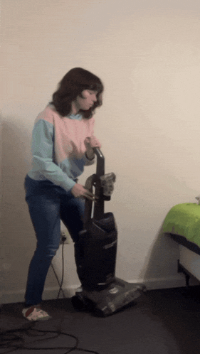 a woman is using a vacuum cleaner in a room
