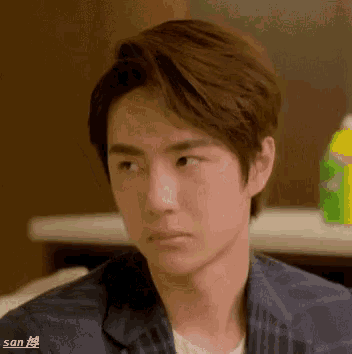 a close up of a young man 's face with a bottle of sprite in the background .