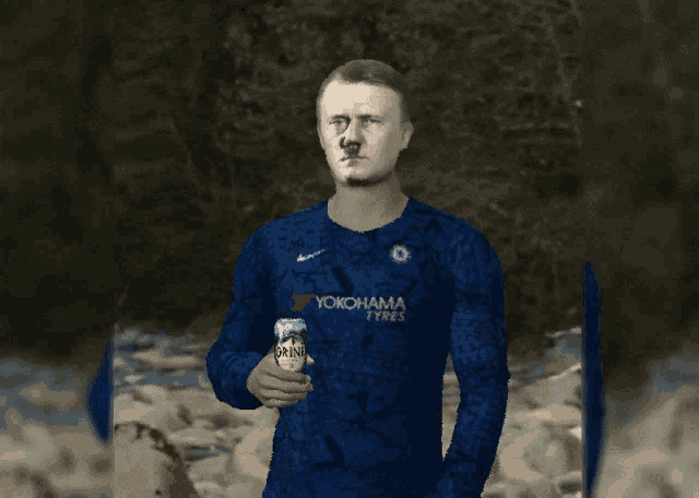 a man in a yokohama shirt holds a can of grim
