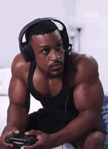 a man wearing headphones is playing a video game with the year 2018 in the background