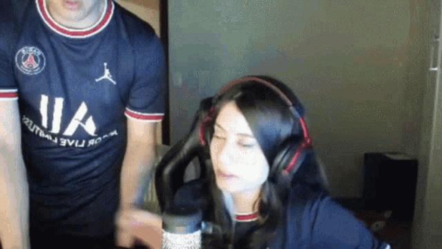 a man and a woman are sitting in front of a microphone .