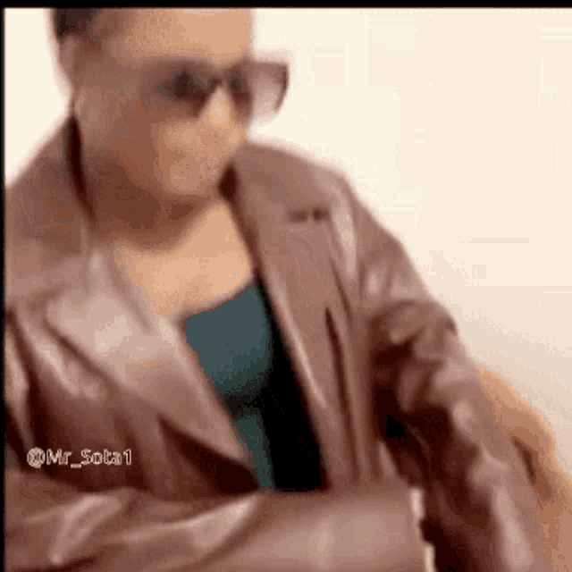 a woman wearing sunglasses and a brown leather jacket has the name mr_sota1 on the bottom right