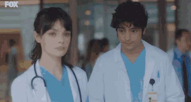 a man and a woman are standing next to each other in a hospital hallway with the fox logo in the corner