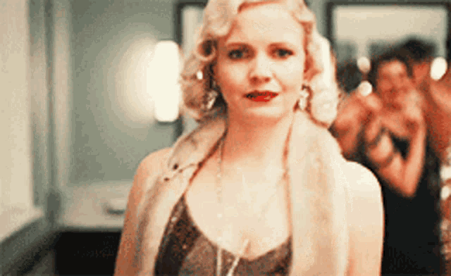 a woman with blonde hair and red lipstick is standing in a room
