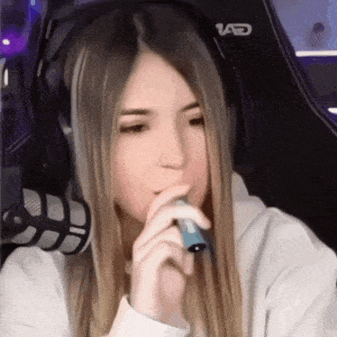 a girl wearing headphones and holding a microphone with the letter ad on the back of her chair