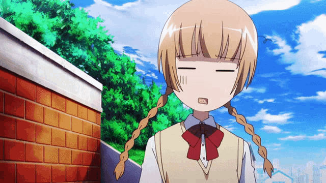 a girl with pigtails is making a funny face in front of a brick wall