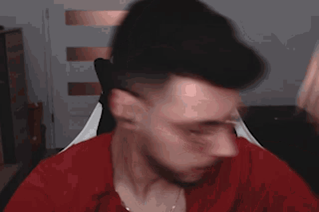 a man wearing glasses and a red shirt is looking down