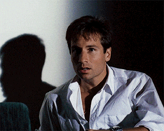 a man in a white shirt is standing in front of a white wall