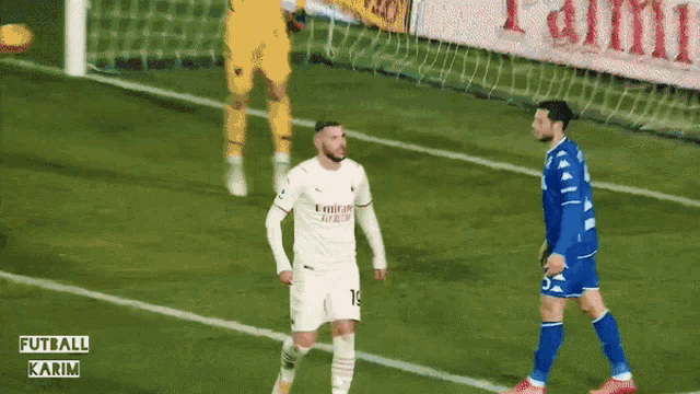 a soccer player wearing a white jersey that says emirates