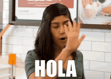 a woman covering her face with her hand and the word hola written on her face