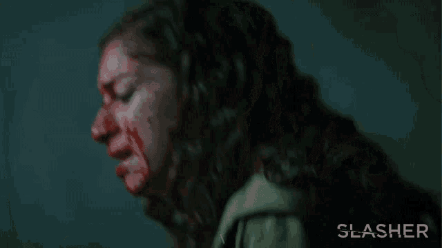 a woman with blood on her face has the word slasher on the bottom right