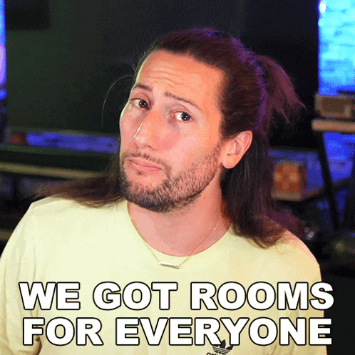 a man with long hair and a beard is wearing a yellow shirt that says " we got rooms for everyone "