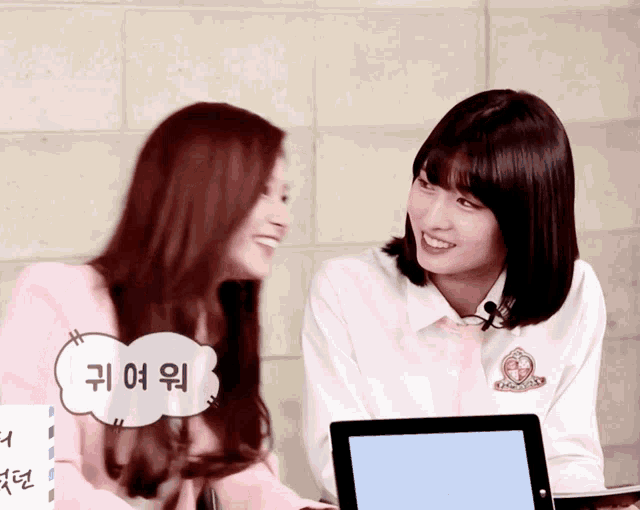 two girls are sitting next to each other and one of them has a speech bubble that says ' 귀여워 ' on it