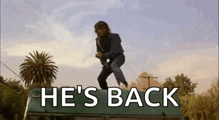 a man is jumping off the roof of a bus with the words `` he 's back '' written on the bottom .