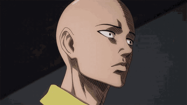 a close up of a bald head with a yellow shirt on