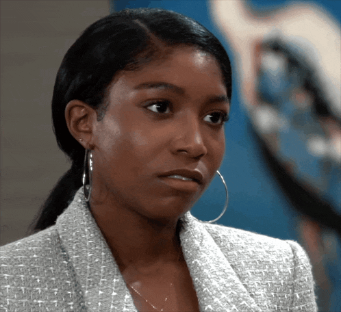 a close up of a woman wearing hoop earrings and a jacket