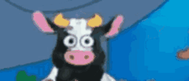 a black and white cow with pink ears and horns is standing in front of a blue background .