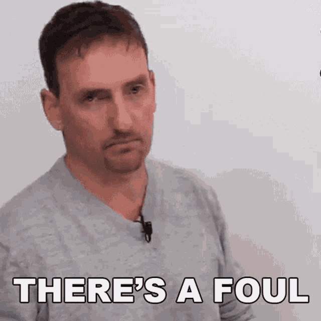 a man says there 's a foul while wearing a grey shirt