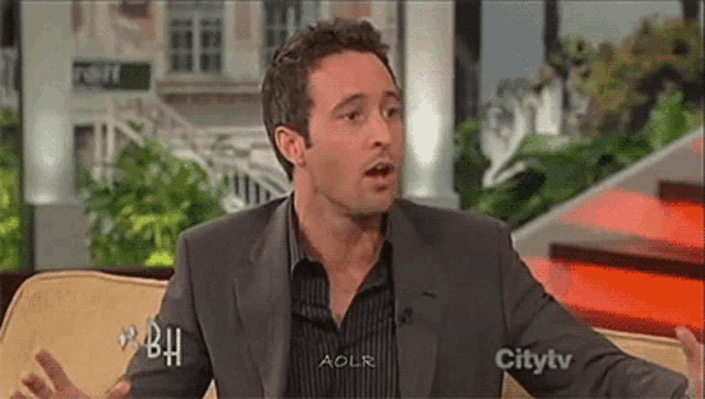 a man in a suit and striped shirt is on a city tv show