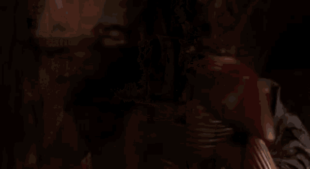 a man is holding a sword in front of a cross in a dark room .