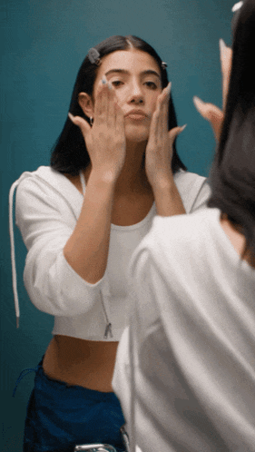 a woman looking at her face in a mirror