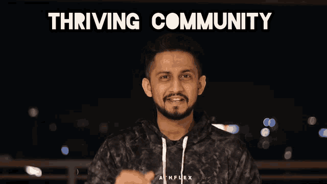 a man stands in front of a poster that says thriving community on it