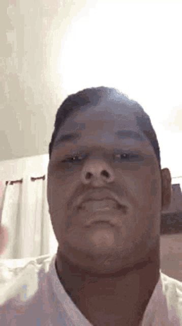a close up of a man 's face with a white shirt on .