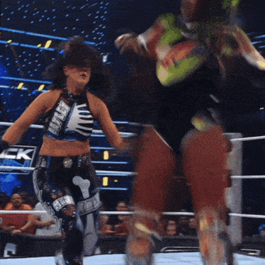 a woman in a wrestling ring is wearing a crop top that says ' wwe ' on it