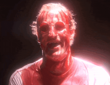 a man with blood on his face is wearing red glasses